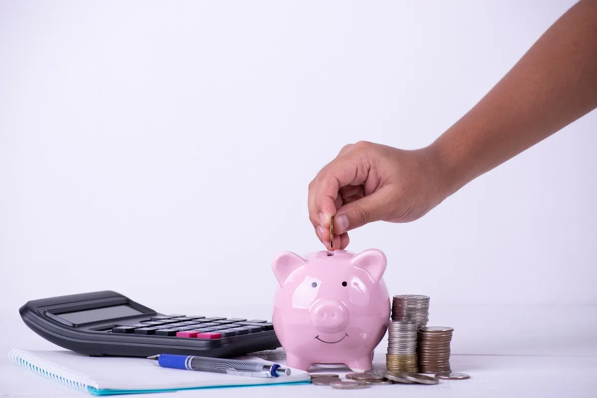 Boy hand put coins to piggy bank, Stack of coins ,calculations ,