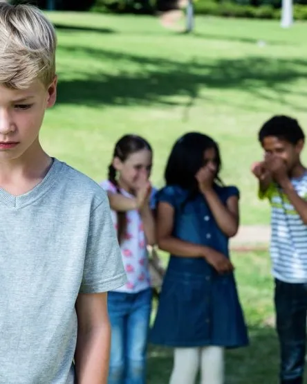 Friends teasing a boy in the park