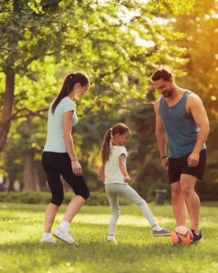 Parents and Daughter Play Football. Guys Smile.