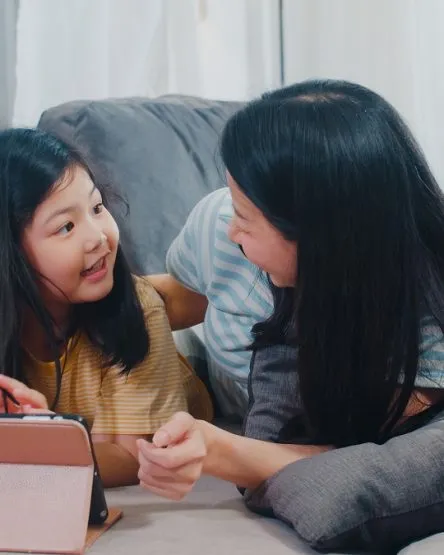 Young Asian family and daughter happy using tablet at home. Japa