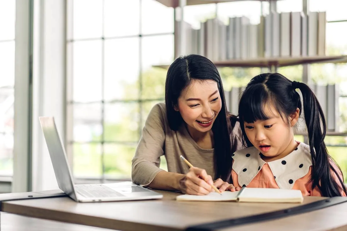 Mother and asian kid little girl learning and looking at laptop