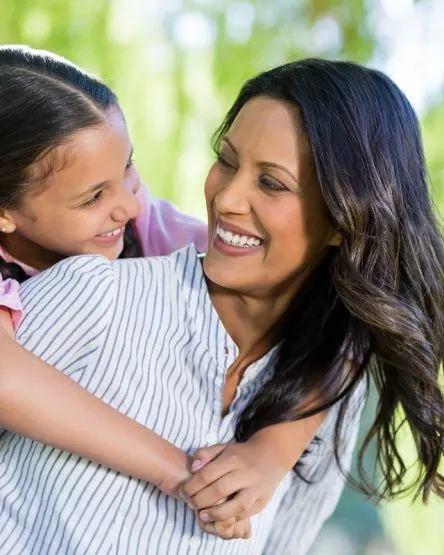 Happy mother giving piggyback ride to her daughter