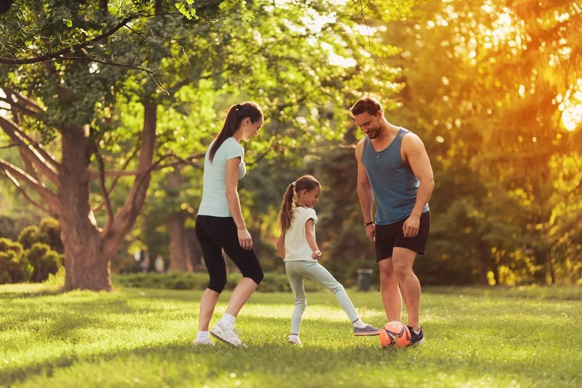 Parents and Daughter Play Football. Guys Smile.