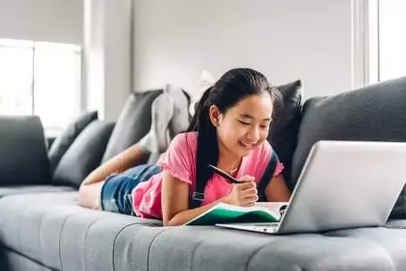 School kid little girl learning and looking at laptop computer m