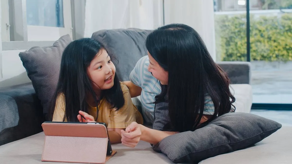 Young Asian family and daughter happy using tablet at home. Japa