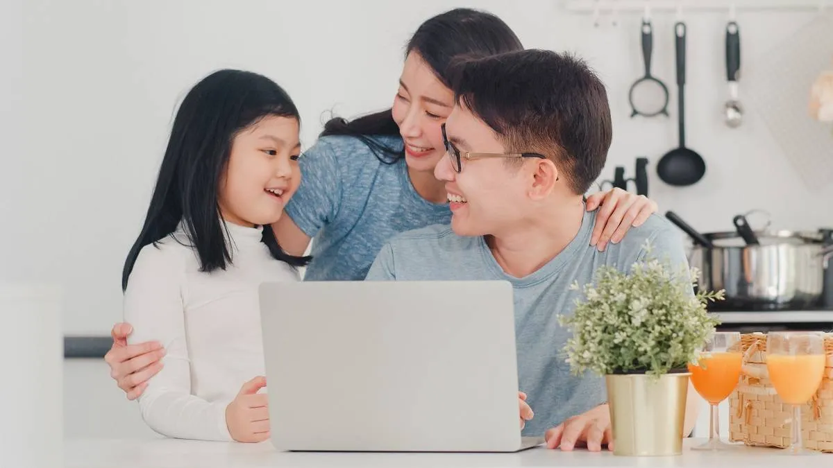 Young Asian family enjoy using laptop together at home. Lifestyl